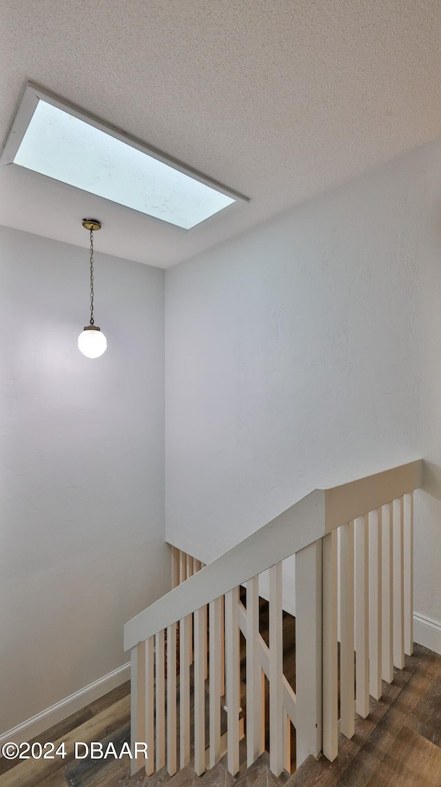 stairway featuring hardwood / wood-style floors and a skylight