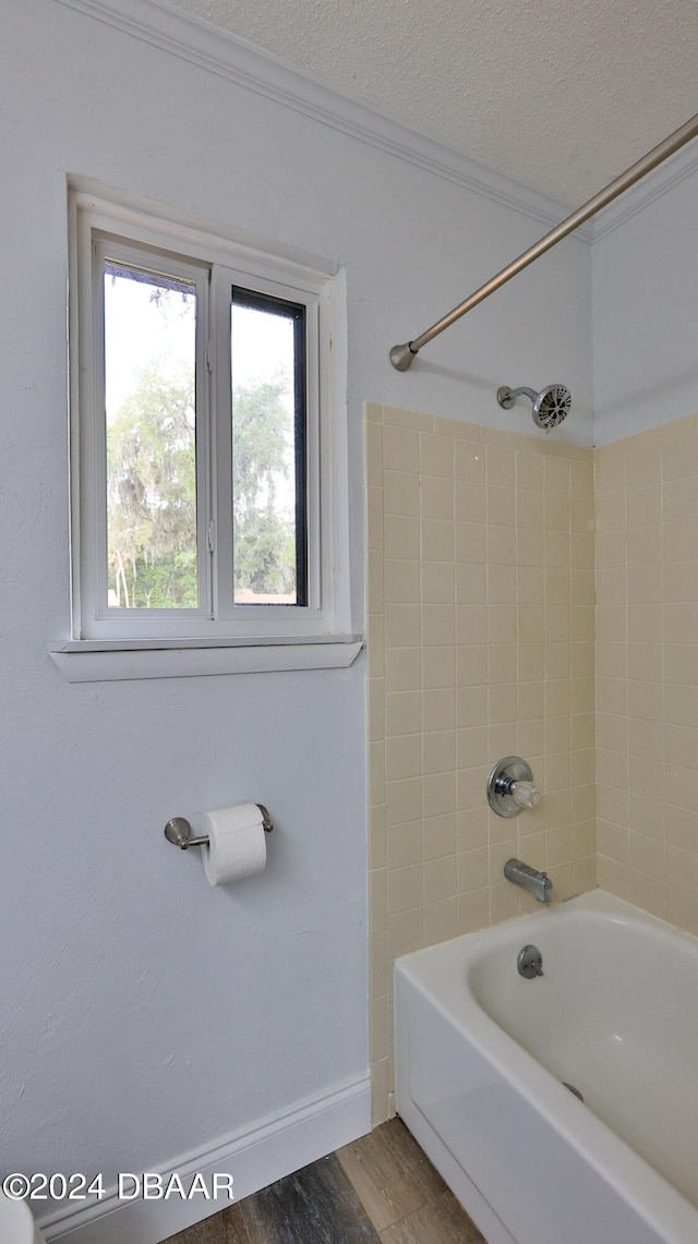 bathroom with tiled shower / bath combo, a textured ceiling, and hardwood / wood-style flooring