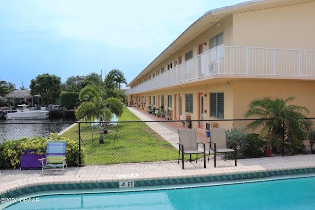 view of pool featuring a lawn and a water view