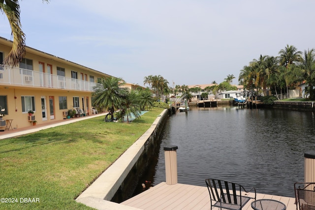 view of dock featuring a water view and a yard