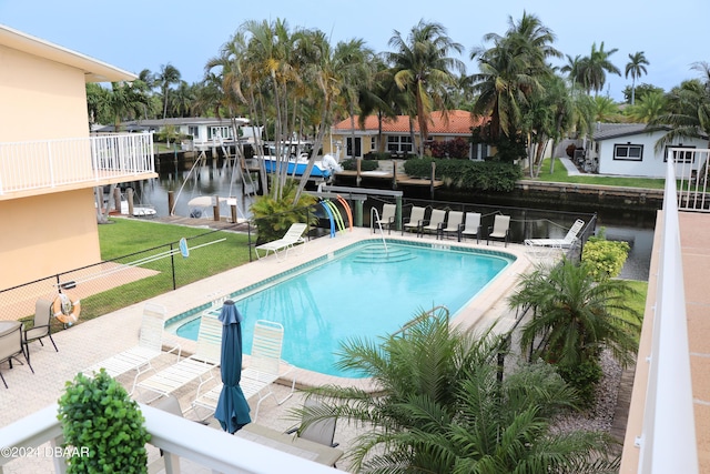 view of pool with a water view and a patio area