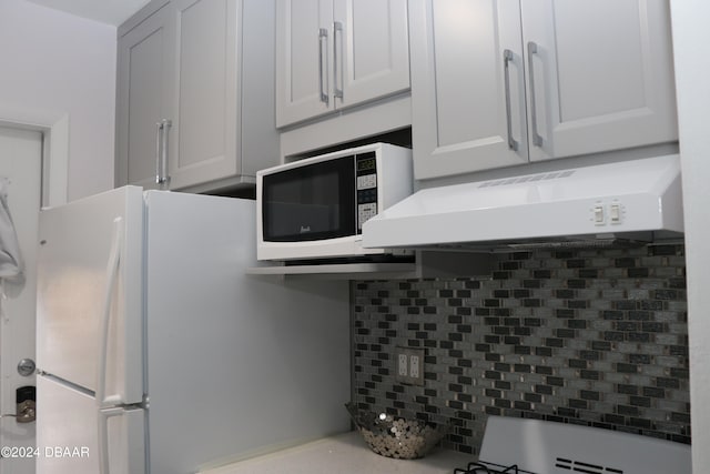 kitchen featuring tasteful backsplash and white cabinetry