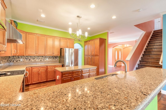 20 Promenade At Lionspaw, Daytona Beach, FL 32124 - kitchen featuring light stone countertops, decorative backsplash, freestanding refrigerator, arched walkways, and a sink