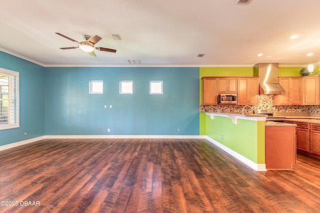 20 Promenade At Lionspaw, Daytona Beach, FL 32124 - kitchen with stainless steel microwave, visible vents, dark wood finished floors, a breakfast bar area, and wall chimney exhaust hood
