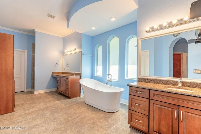 20 Promenade At Lionspaw, Daytona Beach, FL 32124 - full bath featuring visible vents, two vanities, a sink, baseboards, and a soaking tub