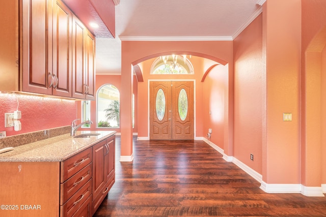 20 Promenade At Lionspaw, Daytona Beach, FL 32124 - foyer featuring dark wood finished floors, crown molding, baseboards, and arched walkways