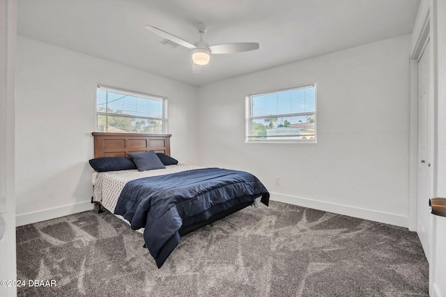 bedroom featuring ceiling fan, dark colored carpet, and a closet