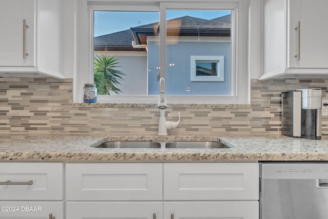 kitchen with stainless steel dishwasher, white cabinetry, and sink