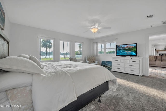 bedroom with ceiling fan, multiple windows, and carpet floors