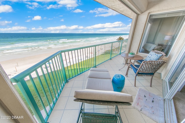 balcony with a water view and a beach view