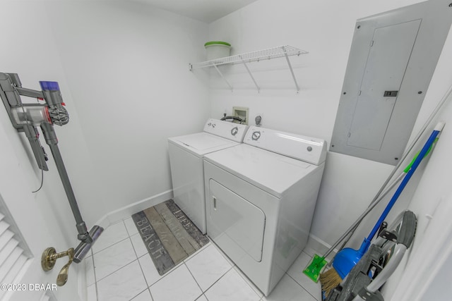 laundry area with electric panel, washing machine and clothes dryer, and light tile patterned flooring