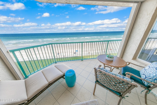 balcony featuring a water view and a view of the beach