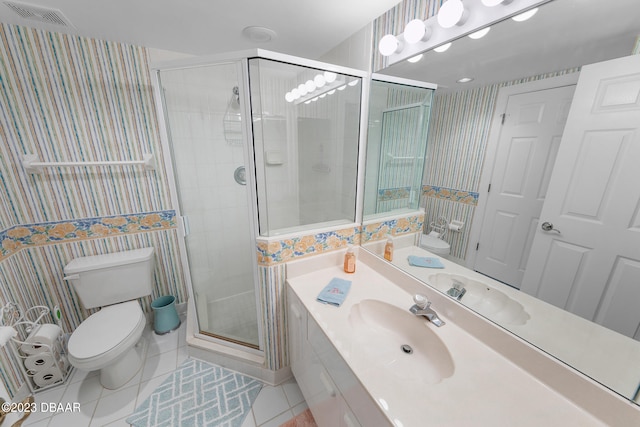 bathroom with vanity, a shower with door, tile patterned floors, and toilet