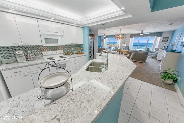 kitchen featuring backsplash, sink, white cabinets, white appliances, and light colored carpet