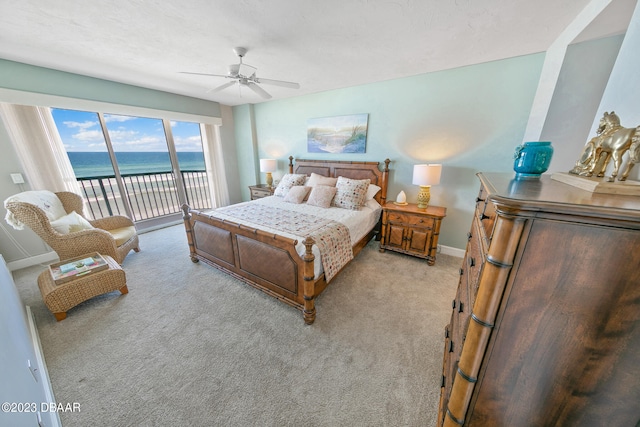 carpeted bedroom with access to outside, a water view, and ceiling fan