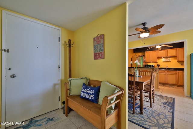 entryway featuring light tile patterned floors, ceiling fan, and sink