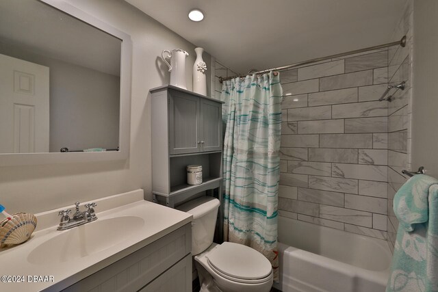 full bathroom with vanity, shower / bath combo with shower curtain, and toilet