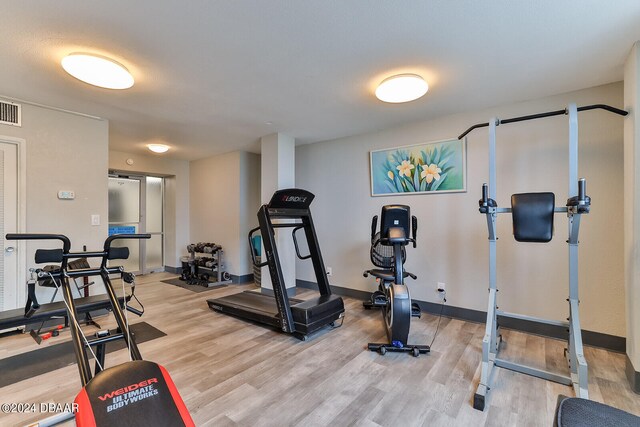 workout area with light hardwood / wood-style flooring