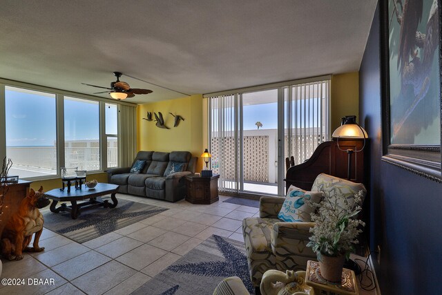 living room featuring a textured ceiling, a wealth of natural light, ceiling fan, and light tile patterned floors