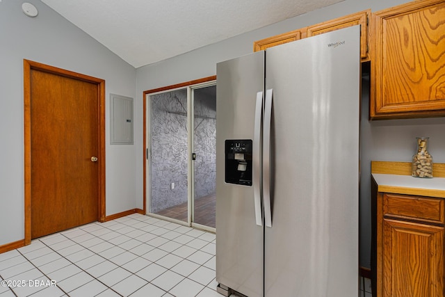 kitchen featuring light tile patterned flooring, stainless steel fridge with ice dispenser, electric panel, and vaulted ceiling