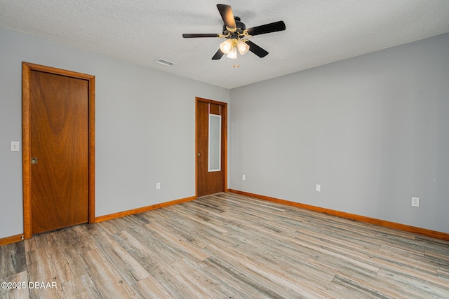 unfurnished room with a textured ceiling, light hardwood / wood-style flooring, and ceiling fan