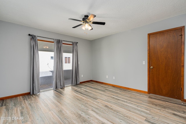 empty room with ceiling fan, light hardwood / wood-style floors, and a textured ceiling