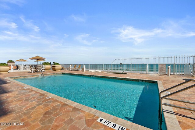 community pool featuring a patio area and fence