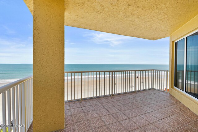 balcony featuring view of water and beach