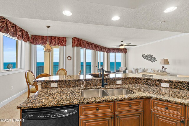 kitchen with a sink, black dishwasher, a water view, ceiling fan, and dark stone counters