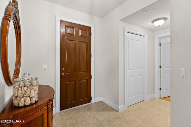 entryway with light tile patterned floors and baseboards