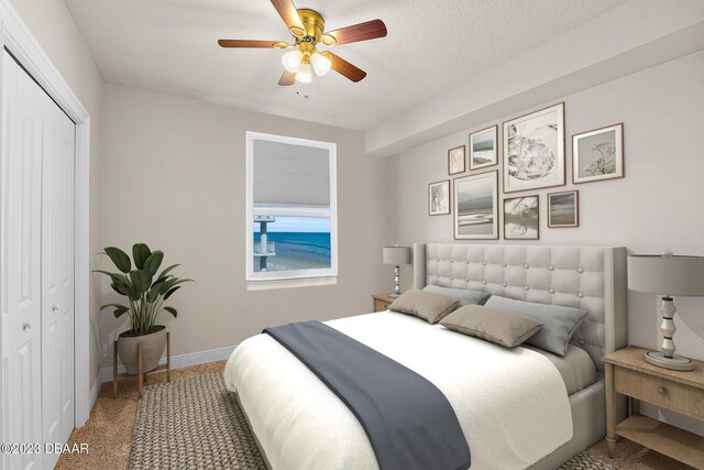 carpeted bedroom featuring a closet, baseboards, and a ceiling fan