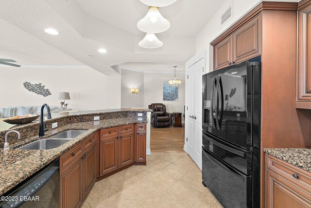 kitchen featuring black appliances, a sink, crown molding, brown cabinetry, and stone counters