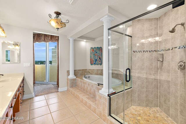 bathroom with decorative columns, tile patterned floors, vanity, a garden tub, and a stall shower