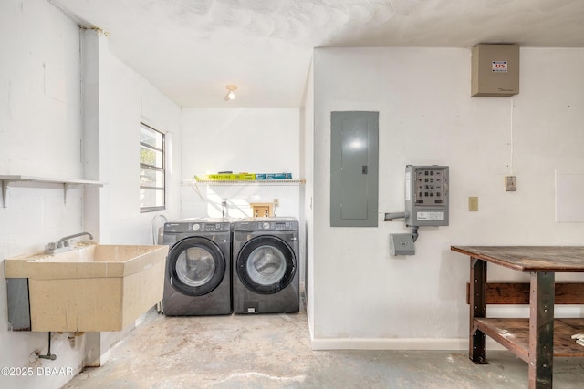 laundry room featuring washer and dryer, electric panel, and sink