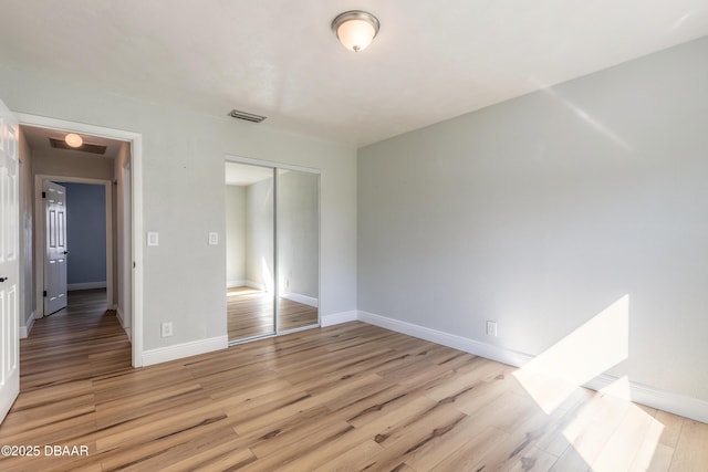 unfurnished bedroom featuring light hardwood / wood-style flooring and a closet