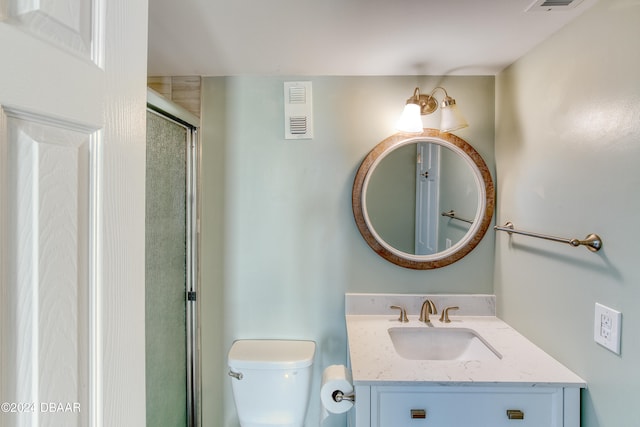 bathroom with an enclosed shower, vanity, and toilet