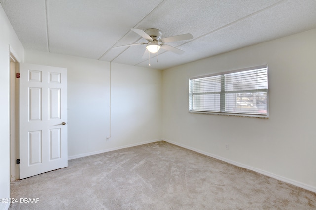 spare room featuring light carpet and ceiling fan