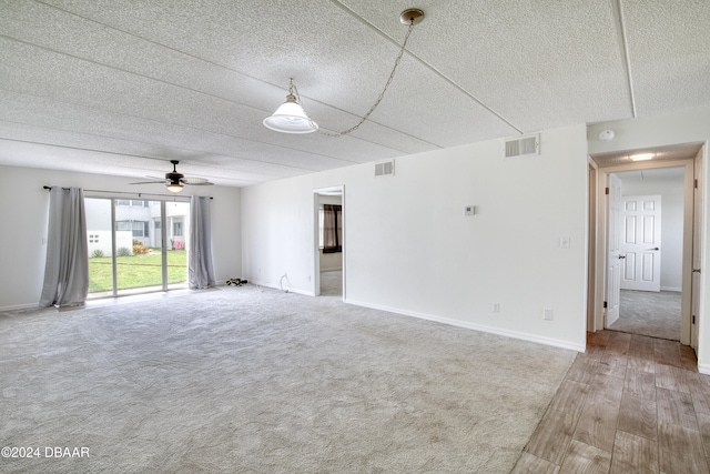 unfurnished room featuring a textured ceiling, hardwood / wood-style flooring, and ceiling fan