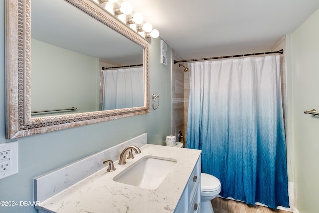 full bathroom with toilet, shower / tub combo with curtain, vanity, and hardwood / wood-style floors