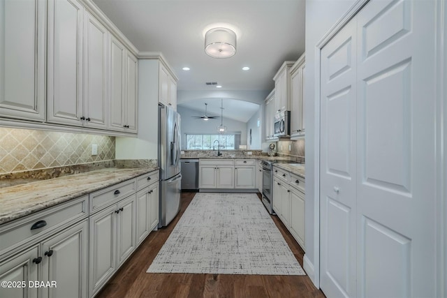 kitchen featuring dark hardwood / wood-style flooring, stainless steel appliances, white cabinets, and lofted ceiling