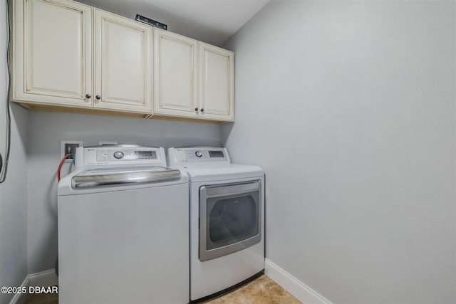 laundry room with washing machine and dryer and cabinets