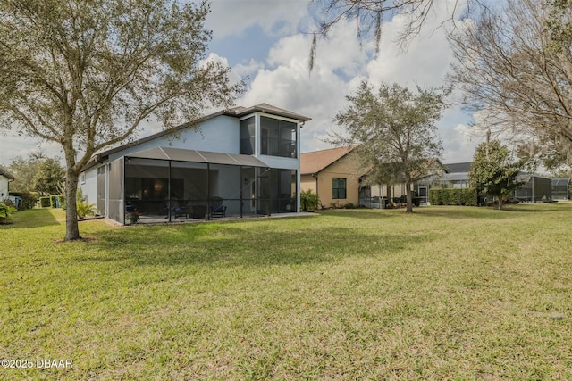 rear view of house featuring a yard and glass enclosure