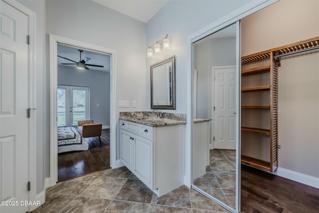 bathroom with hardwood / wood-style flooring, ceiling fan, vanity, and french doors