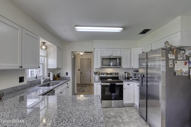 1408 Mollie Rd, Daytona Beach, FL 32114 - kitchen featuring appliances with stainless steel finishes, light stone counters, and white cabinets