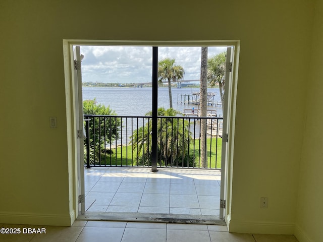 doorway featuring baseboards, tile patterned flooring, and a water view