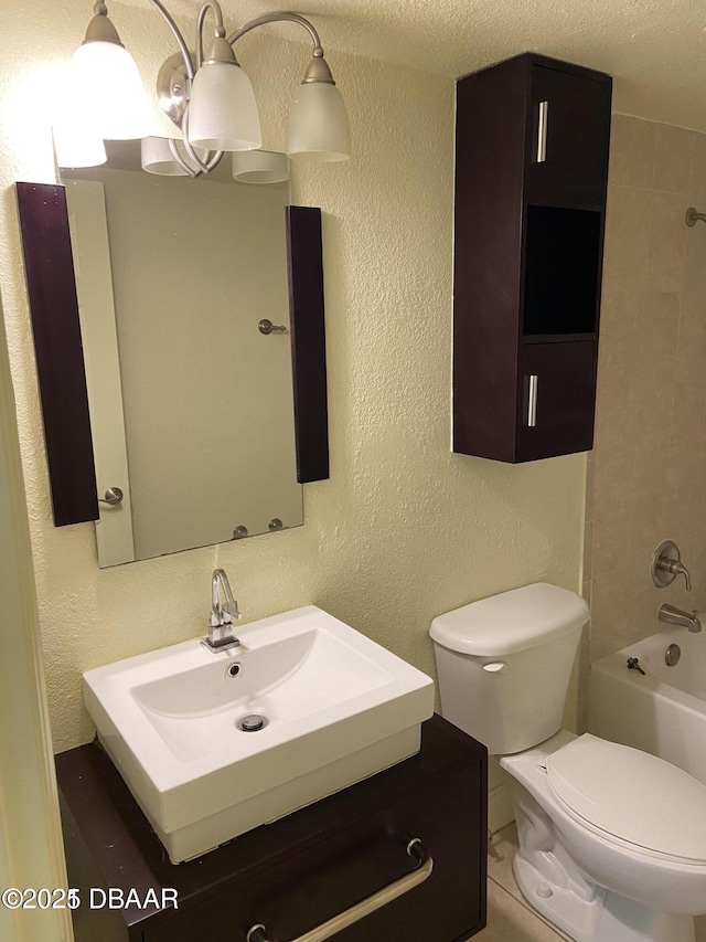 full bathroom with toilet, shower / bath combination, a textured wall, and vanity