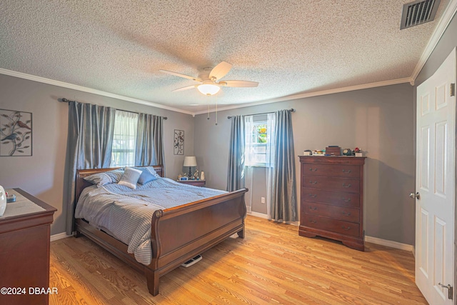 bedroom featuring light hardwood / wood-style floors, ceiling fan, a textured ceiling, and crown molding