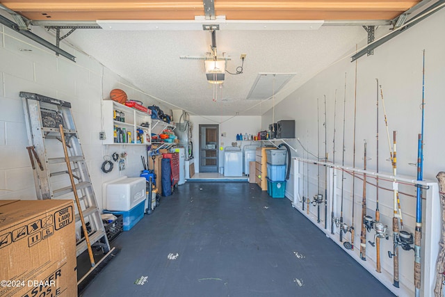 garage with separate washer and dryer and a garage door opener