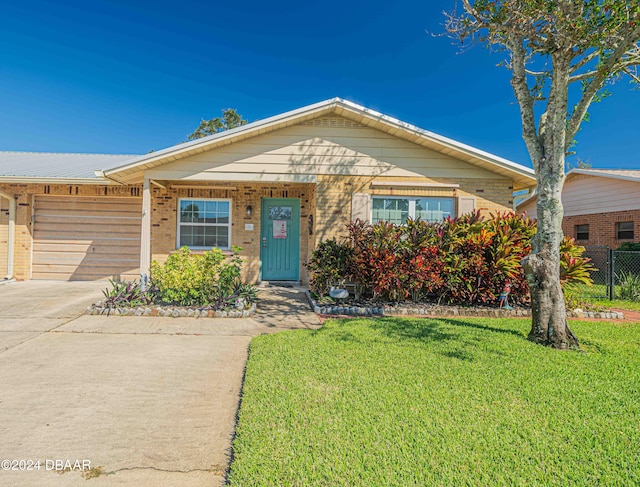 view of front of property featuring brick siding, concrete driveway, and a front lawn