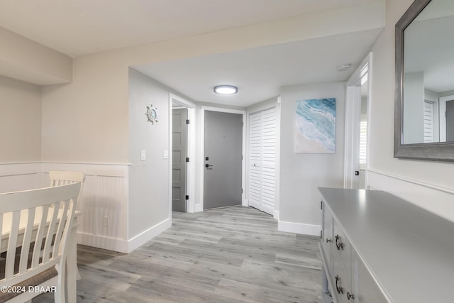 hallway featuring baseboards and light wood finished floors